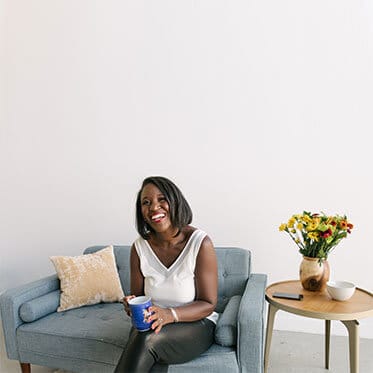 A woman sitting on top of a blue couch.