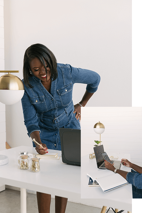 A woman is smiling while using her laptop.