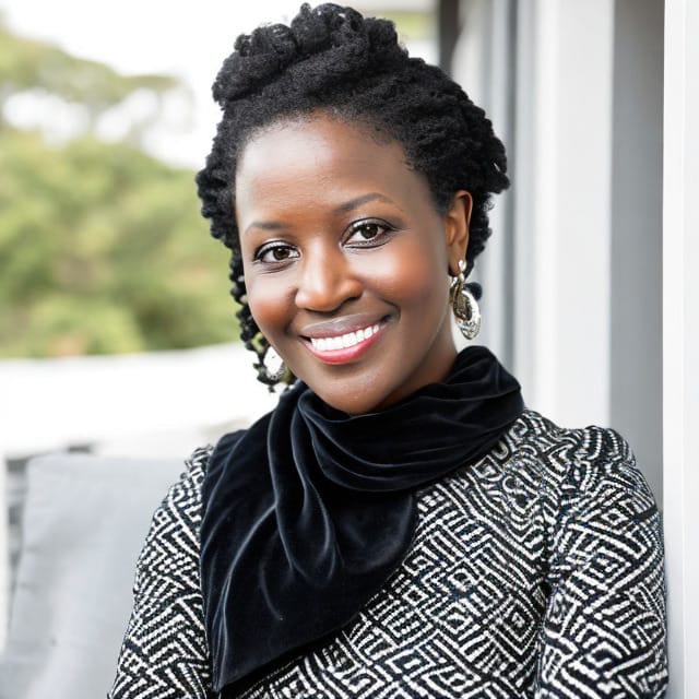 A woman with black and white dress smiling for the camera.