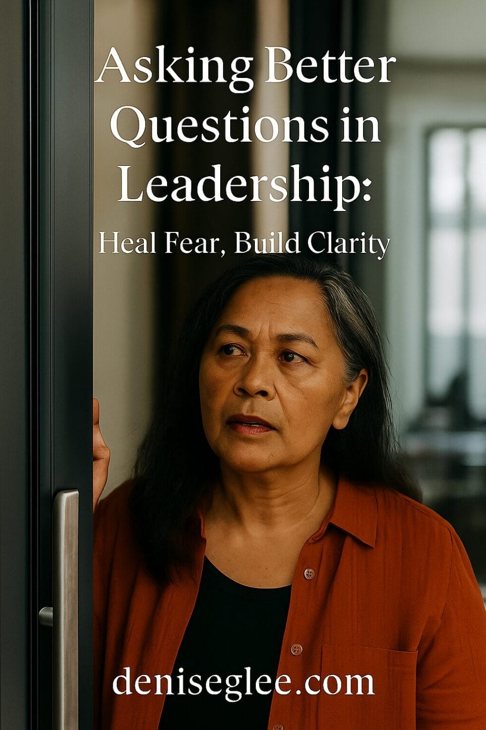 Pacific Islander woman in her early 50s standing in a doorway, looking thoughtful and concerned, representing the emotional pause before asking a difficult question in leadership.