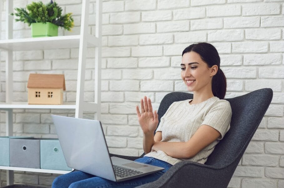 woman waving hands staring at laptop smiling