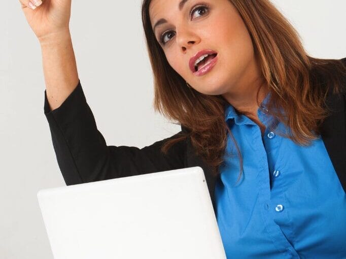 woman at desk signaling for help