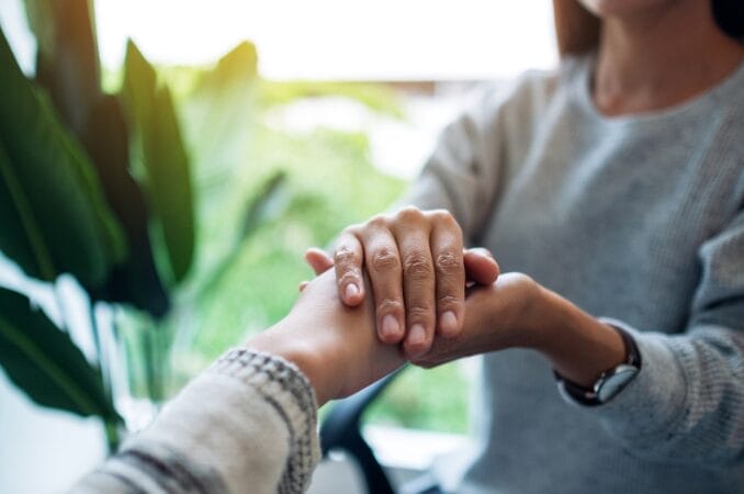 woman holding the hand of another person