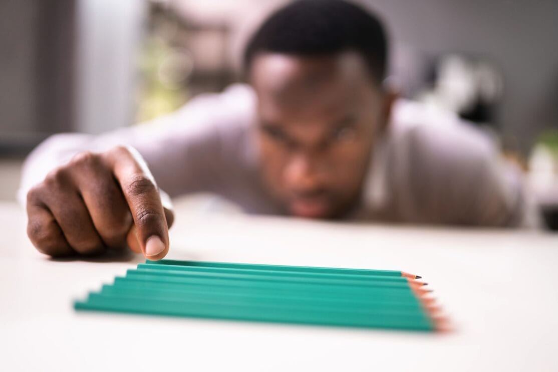 man lining up pencils