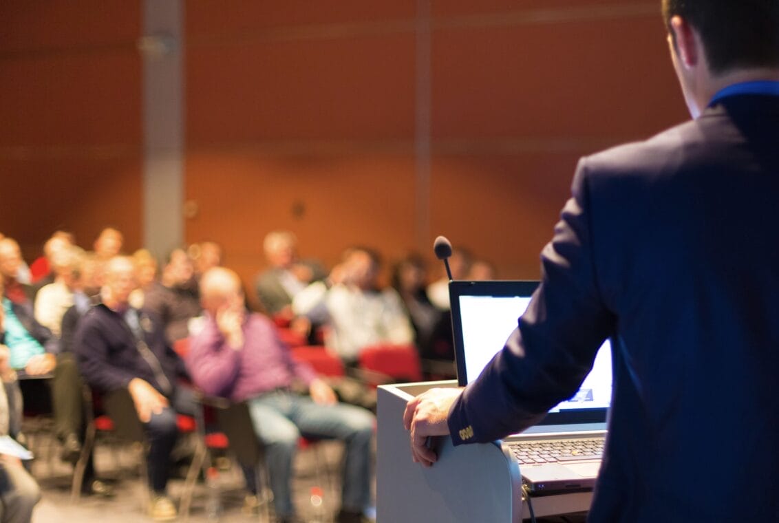 man speaking at a lectern