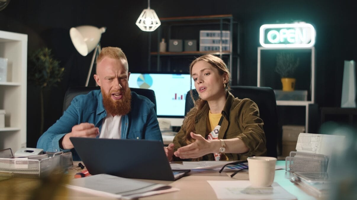 two people at work looking at laptop