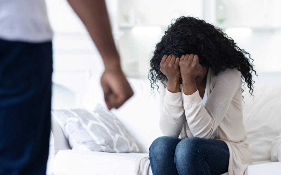 covering face in front of a man with hands balled into fist