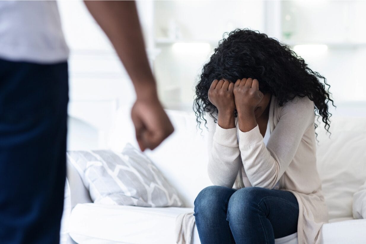 covering face in front of a man with hands balled into fist