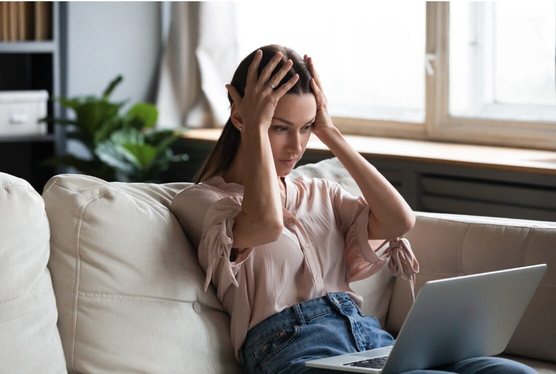 woman looking at laptop nervously