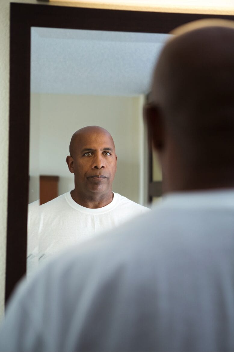 man looking at himself in mirror