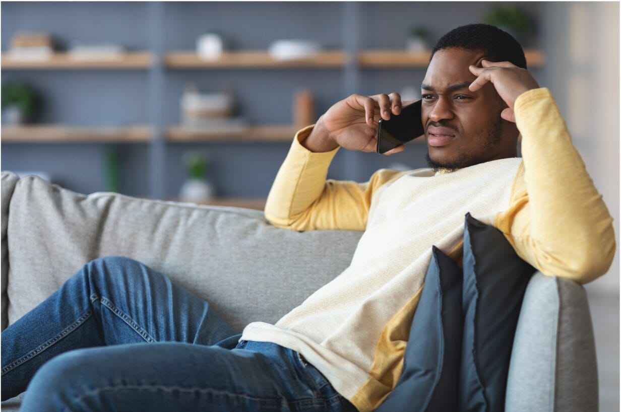 man upset while listening to someone on phone