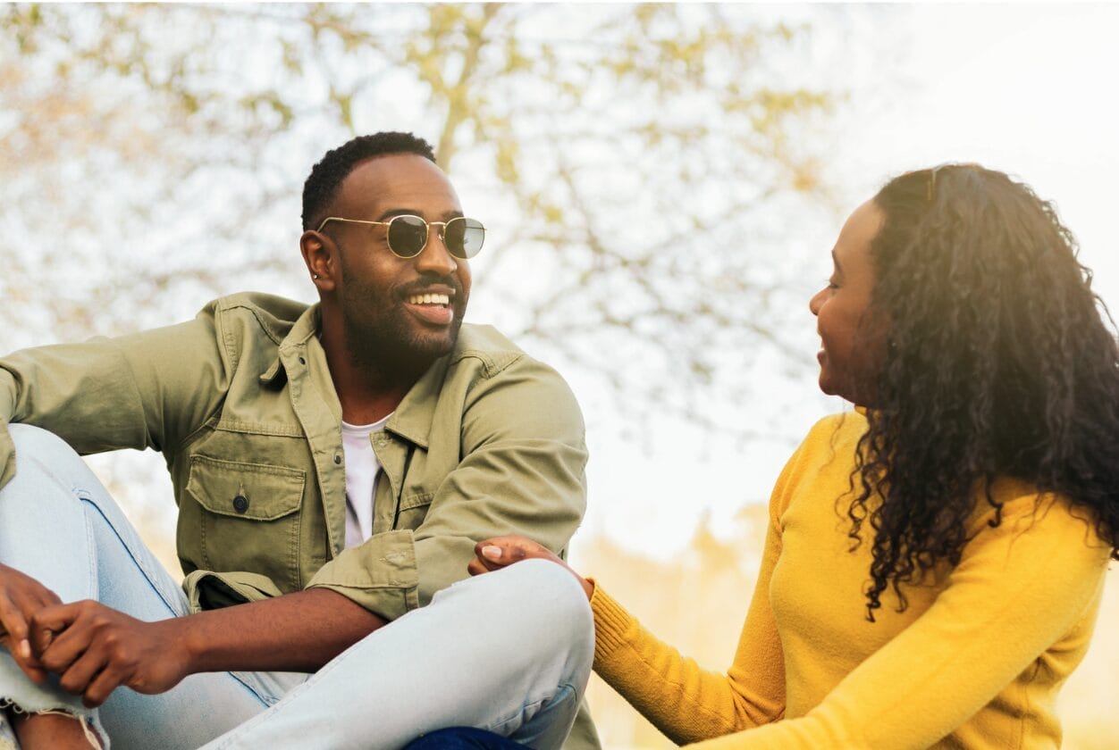 man wearing sunglasses talking with a woman