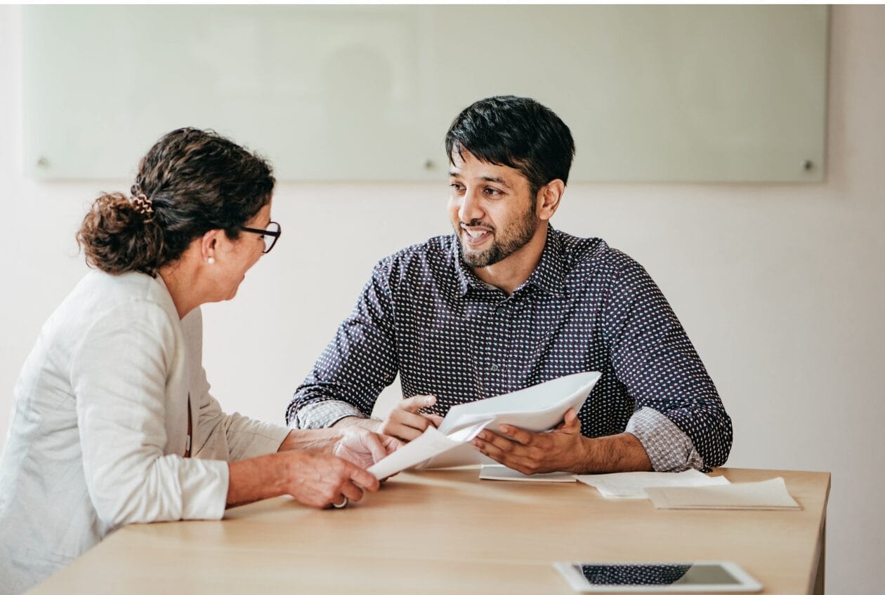 two people talking whiel man holds paper