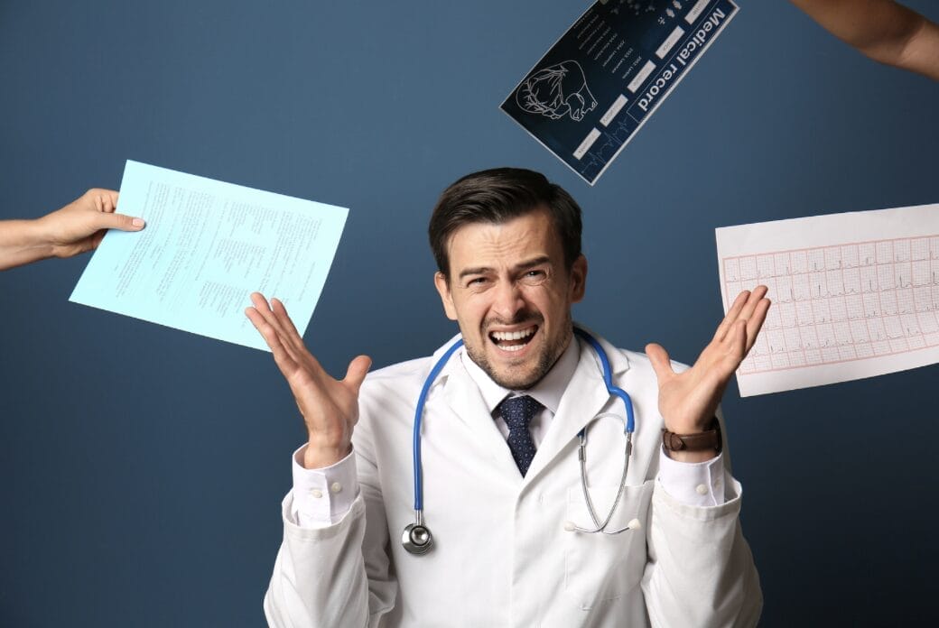 doctor surrounded by hands and paperwork