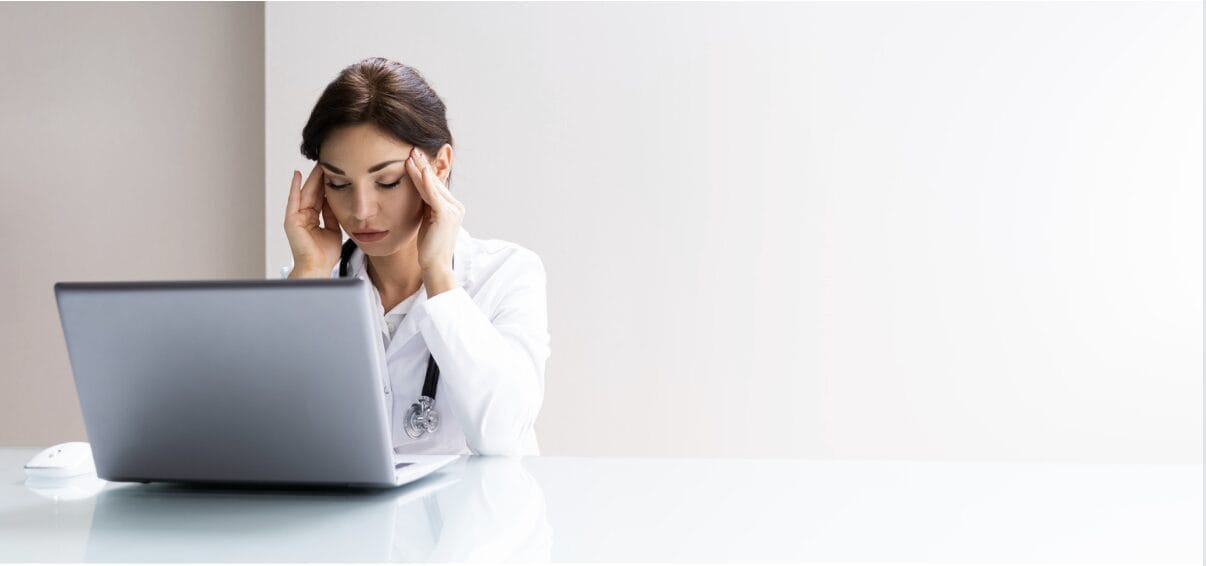 female doctor kneeling against laptop