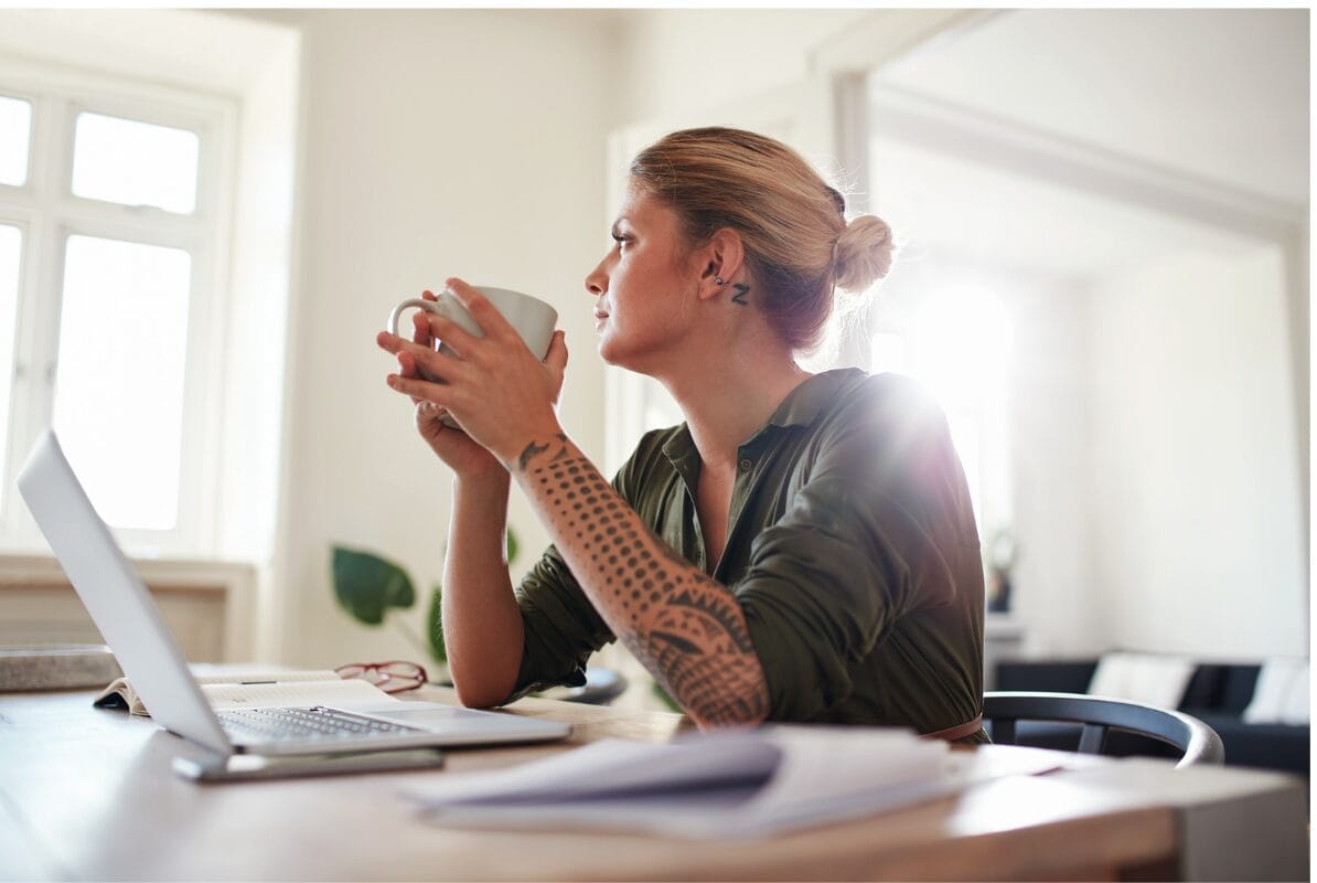 woman with tattoos looking outside