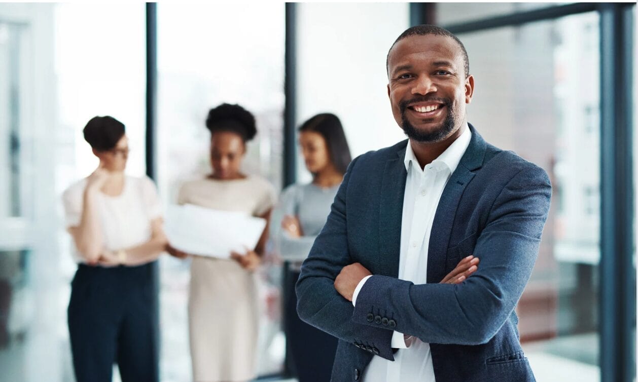 black man in front of others at work