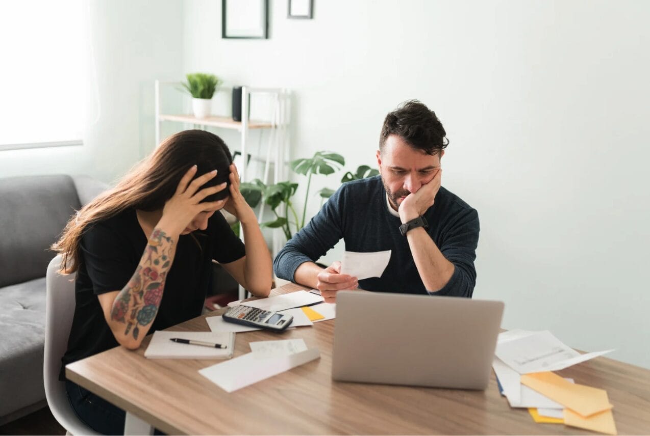 a couple looking frustrated over their finances