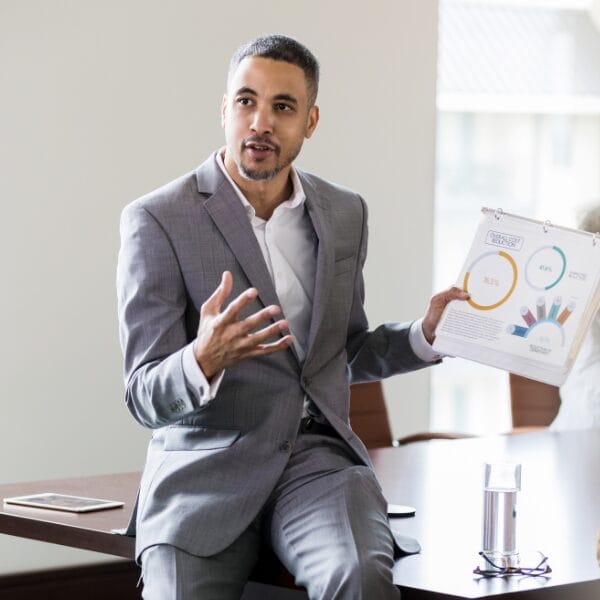 man seated and holding up presentation