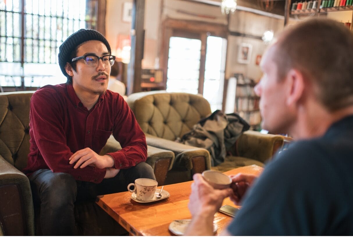 two men talking over coffee