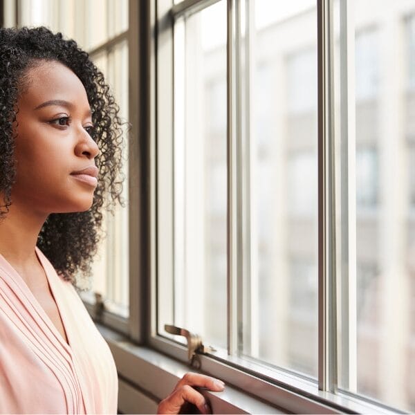 woman staring out window and thinking