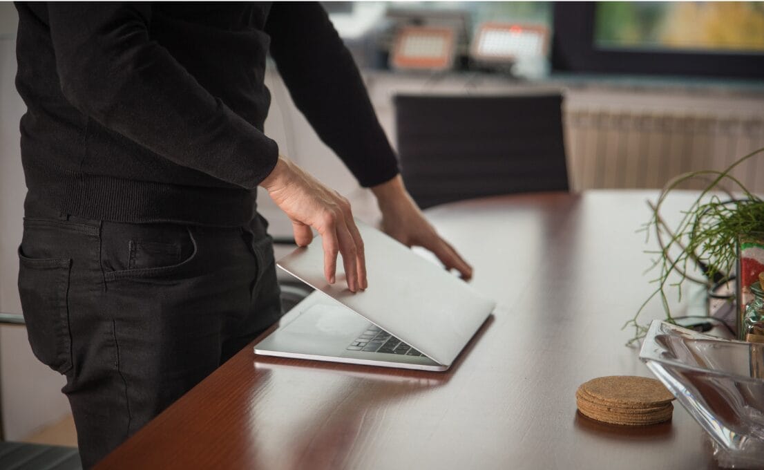 man closing down laptop