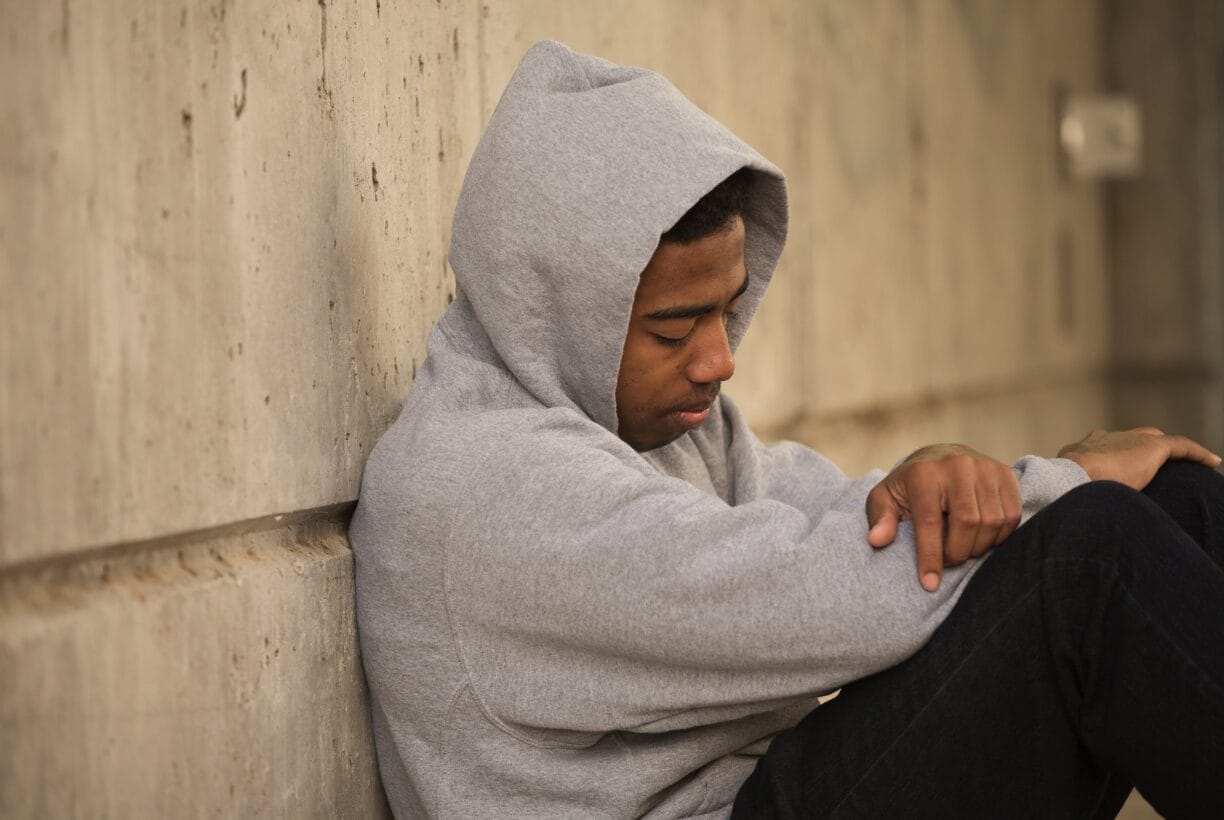 boy on floor wearing hoodie