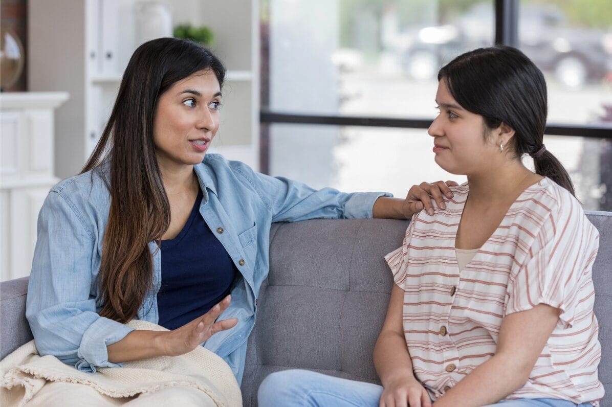 two women on couch talking