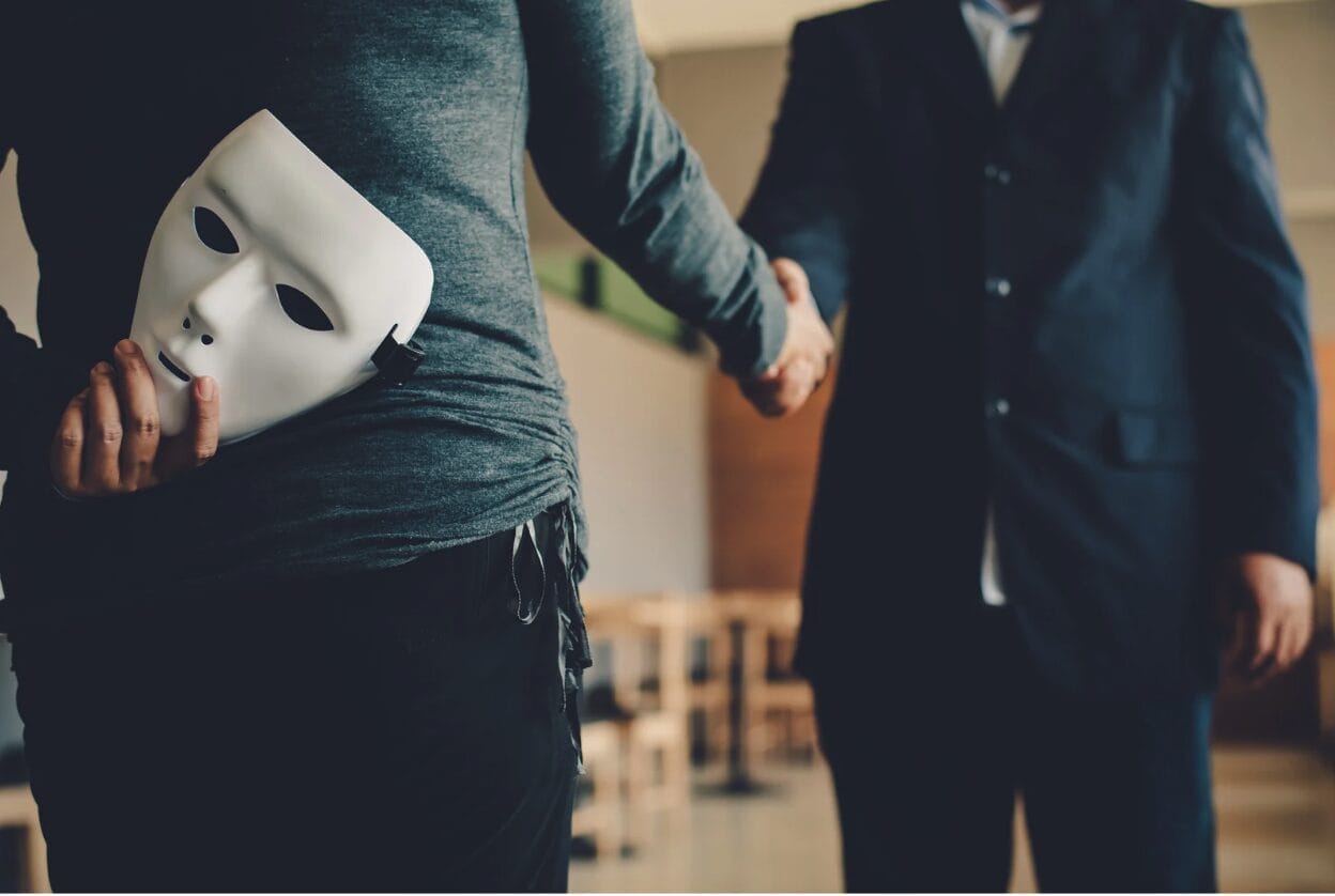 woman hiding mask while shaking hand