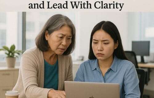 A realistic photo of an older East Asian woman leaning over to help a younger East Asian woman who looks frustrated at her laptop, set in a bright modern office—visually capturing the emotional tension of overfunctioning leadership.