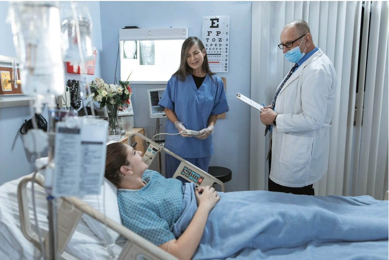 patient in hospital bed with medical staff