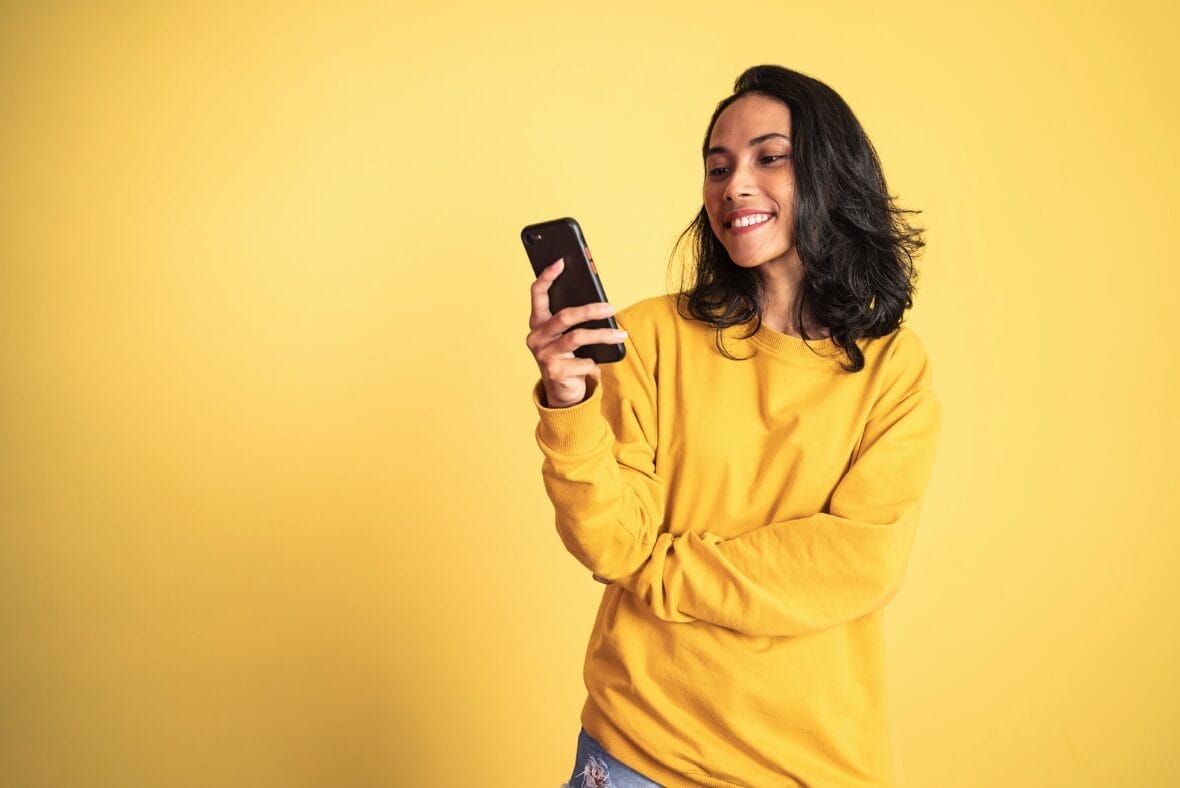 woman in yellow holding phone