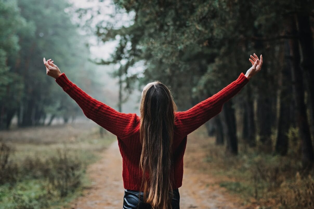 woman hands stretched out in the forest