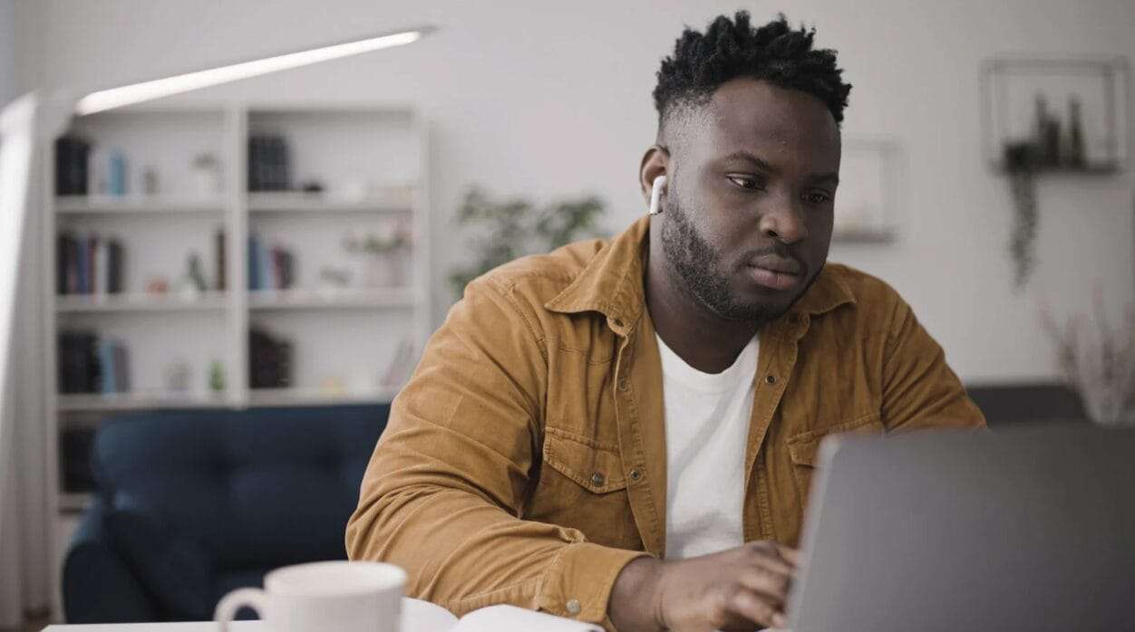 black man staring at laptop