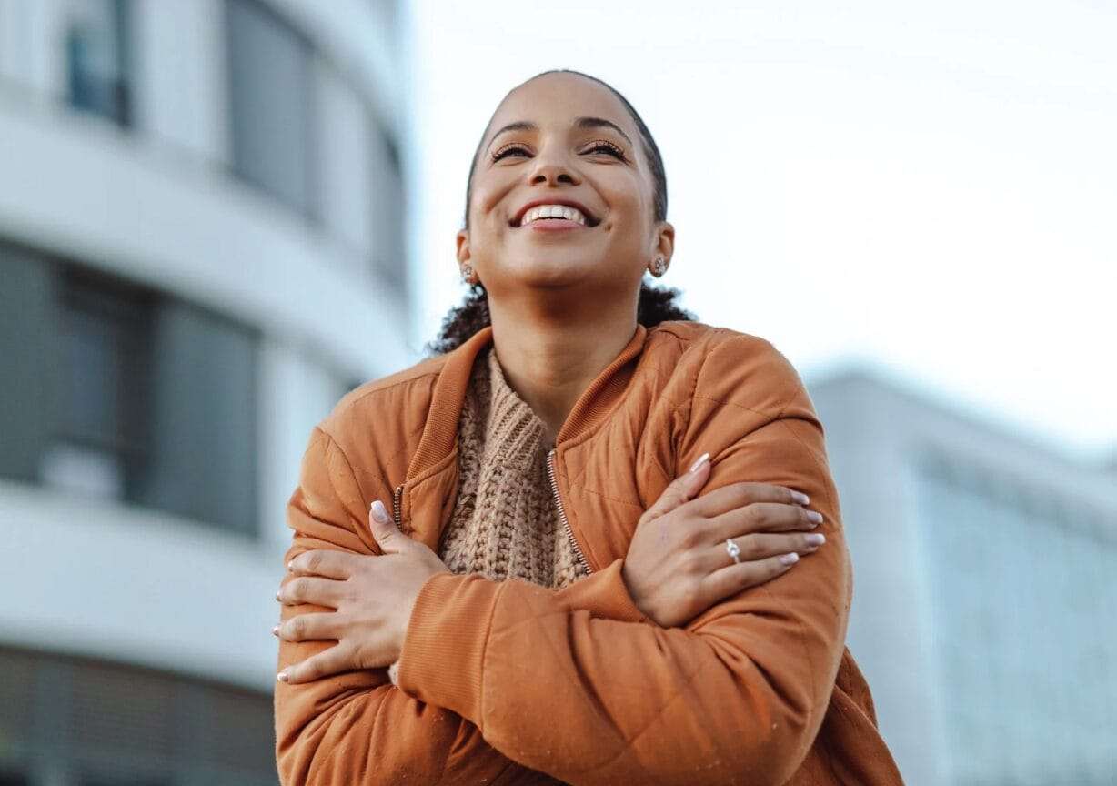 woman outside embracing herself