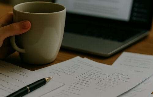A person holding a coffee mug at a desk with papers and a laptop, overlaid with the full title “How to Lead a Team Without Losing Yourself” at the top and deniseglee.com at the bottom