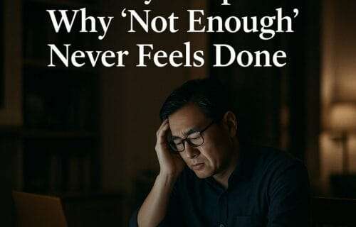 Middle-aged Asian professional man sitting in a dimly lit luxury home office, looking stressed and thoughtful under text reading ‘The Inherited Scarcity Script: Why ‘Not Enough’ Never Feels Done.