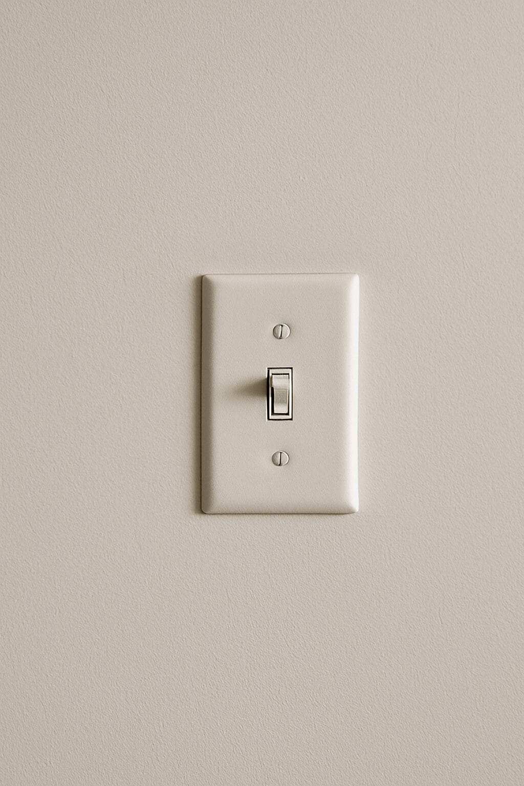 a single light switch against a white wall